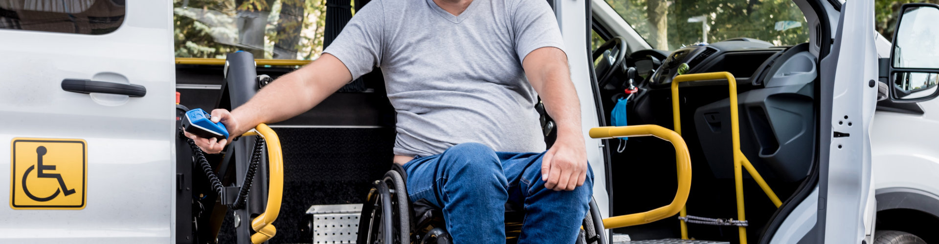 a man in a wheel chair getting inside of car